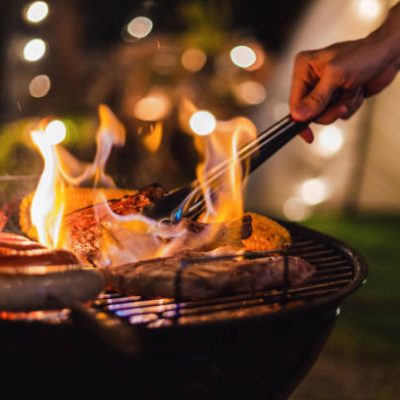 Family making barbecue in dinner party camping at night
